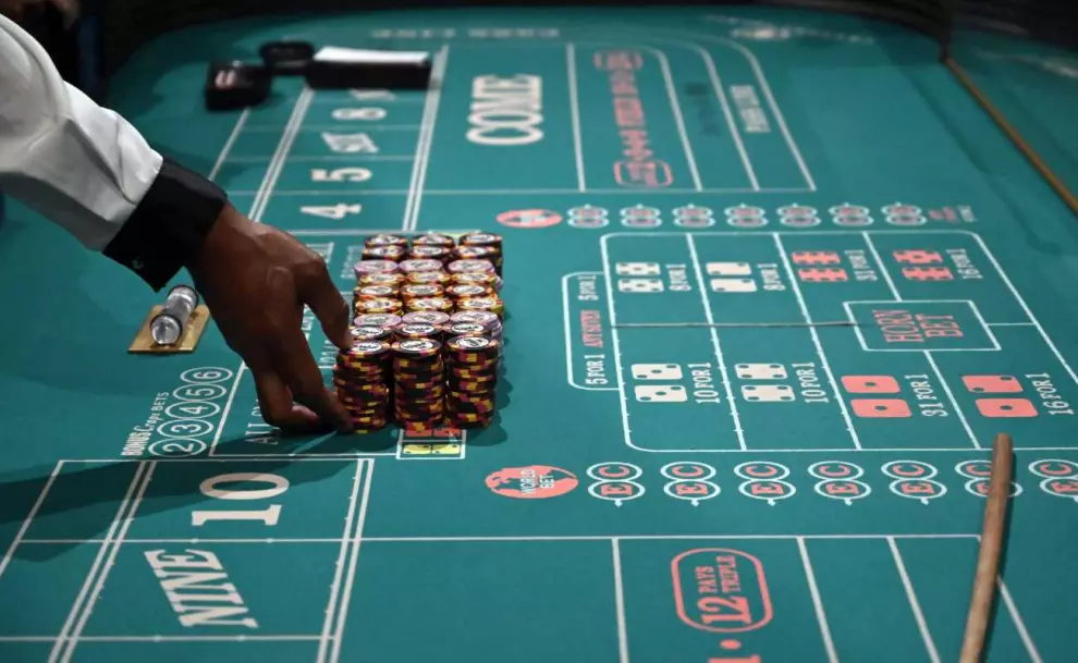 hand placing the chips on craps table in a casino